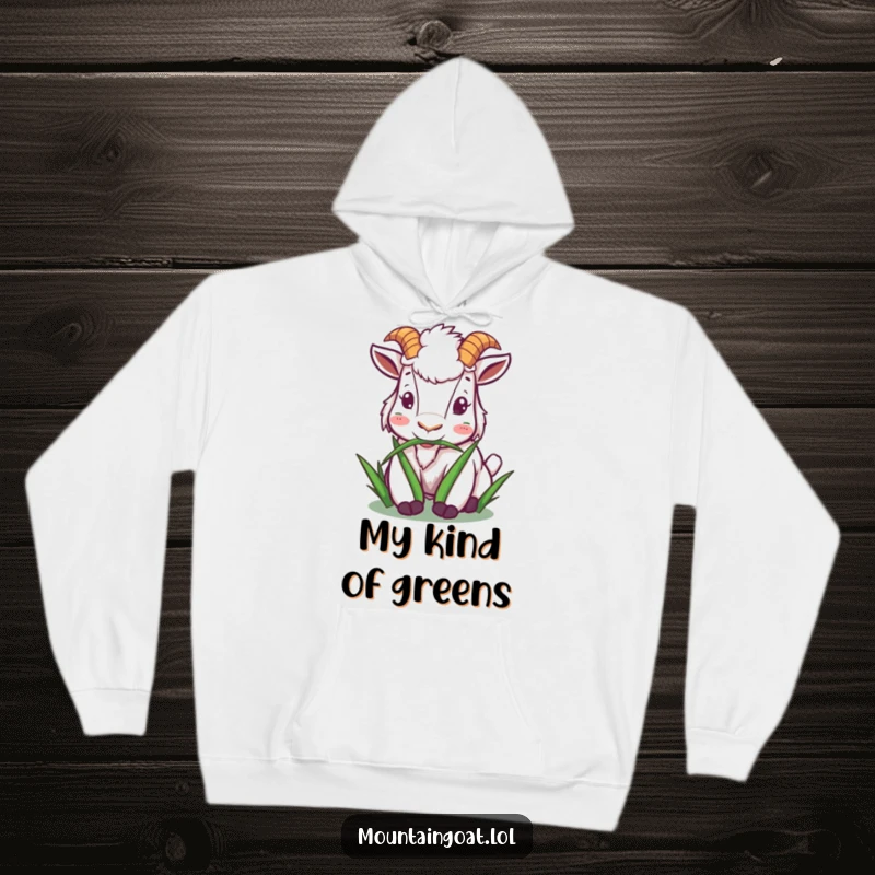 Funny mountain goat hoodie showing a character happily munching on grass, perfect for warmth and spreading peaceful joy.