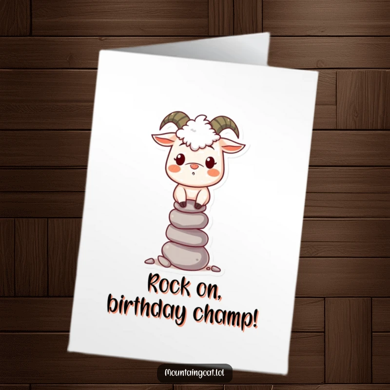 Funny free printable birthday card: A smiling mountain goat precariously balancing a tall stack of pebbles with a joyous expression.